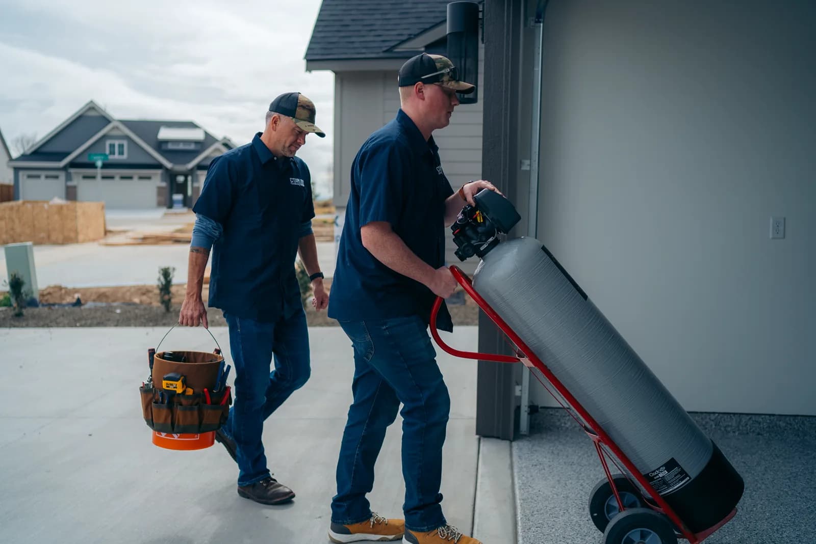 CTA Plumbing technicians moving water softener equipment into a Treasure Valley home